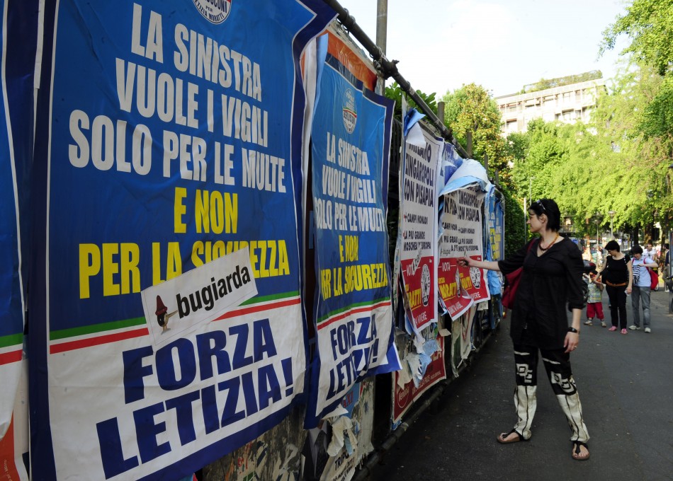 A woman looks at political banners supporting Milans mayor Letizia Moratti in downtown Milan
