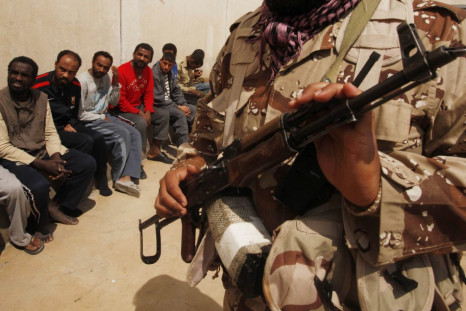 Rebel guards suspected mercenaries and forces loyal to Libyan leader Muammar Gaddafi inside a prison in Benghazi