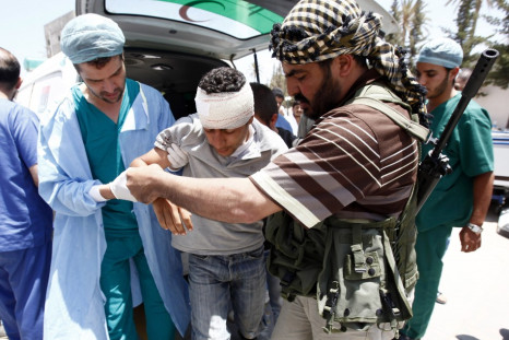 A rebel fighter and a medic assists an injured rebel fighter at a field hospital near Misrata&#039;s western front line