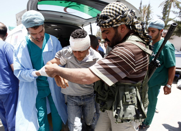 A rebel fighter and a medic assists an injured rebel fighter at a field hospital near Misrata&#039;s western front line