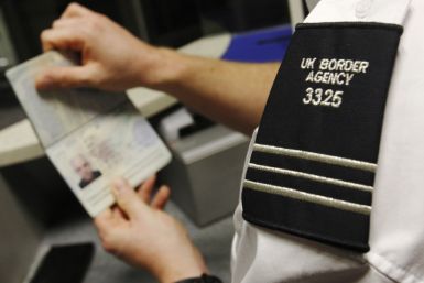 A UK Border Agency representative checks a passport
