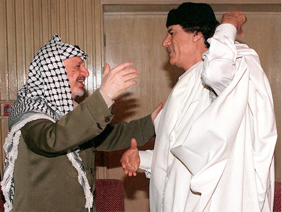 Palestinian President Yasser Arafat  reaches to embrace Libyan revolutionary leader Muammar Gaddafi