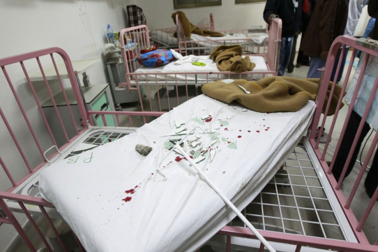 Broken glass are pictured on a blood-stained bed in Tripoli