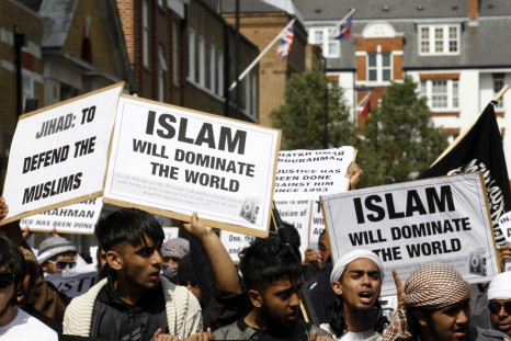 Muslims hold placards as they march towards the U.S. embassy in London May 6, 2011