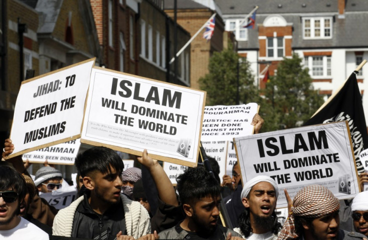 Muslims hold placards as they march towards the U.S. embassy in London May 6, 2011