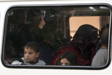 Syrian refugee children look out of a window of a bus as they are driven to a refugee camp in the Turkish border town of Yayladagi