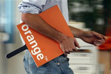 An employee holds a logo for the Orange mobile phone network provider in a retail store in Bordeaux