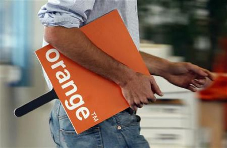 An employee holds a logo for the Orange mobile phone network provider in a retail store in Bordeaux