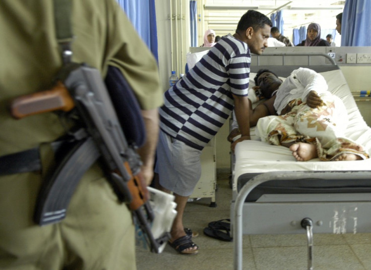 A Sri Lankan policeman stands guard beside the bed of K.P. Mohan, an ethnic Tamil Journalist, in the National Hospital in Colombo