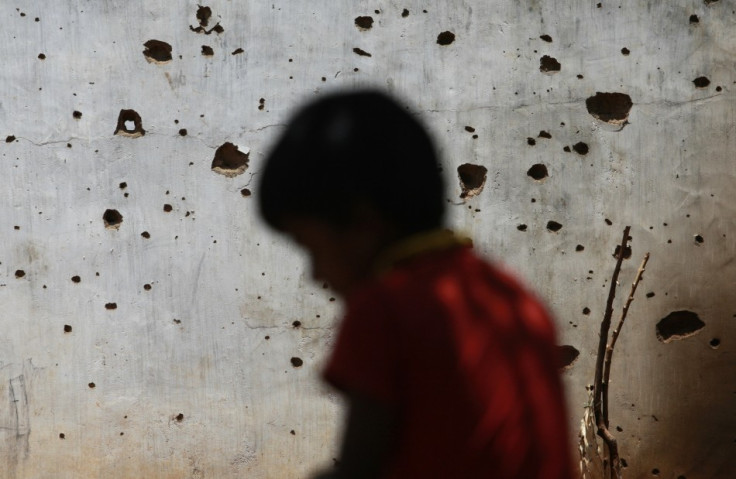 A resettled Tamil IDP sits next to his house, which was damaged from the war between Liberation Tigers of Tamil Eelam and the government, in Vavuniya