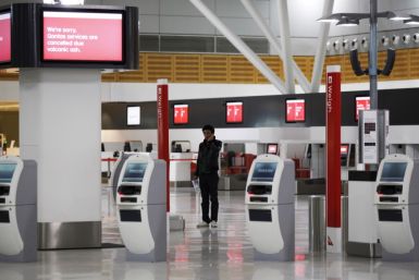 A passenger uses his mobile phone at the almost deserted Qantas domestic terminal in Sydney's airport