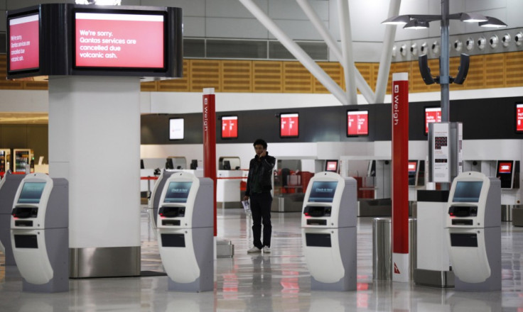 A passenger uses his mobile phone at the almost deserted Qantas domestic terminal in Sydney's airport