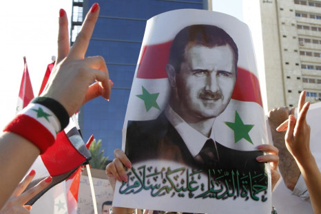 A pro-Syrian President Bashar al-Assad supporter, who rallied to a Facebook call to sit-in to support the army at Arnous square, carries his picture in Damascus