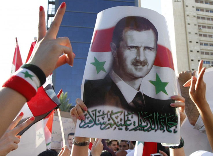 A pro-Syrian President Bashar al-Assad supporter, who rallied to a Facebook call to sit-in to support the army at Arnous square, carries his picture in Damascus