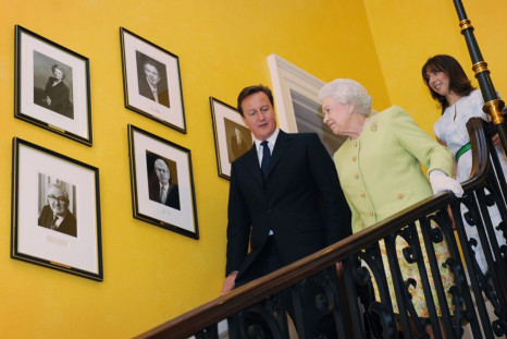 Britain's Queen Elizabeth walks down the staircase at number 10 Downing Street with Prime Minister David Cameron and his wife Samantha