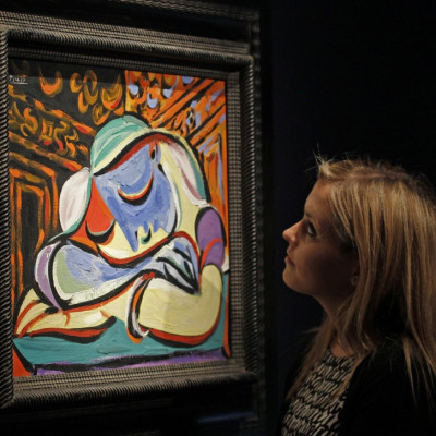 A employee poses with Pablo Picasso's "Jeune fille endormie" at Christie's auction house in London