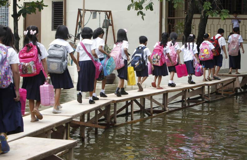 School children cross a flooded area brought by Typhoon Sepat in Valenzuela city, north of Manila