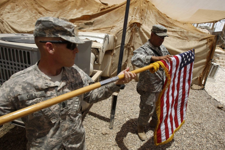 U.S. soldiers fold their national flag as they prepare to hand over their base to Iraqi forces