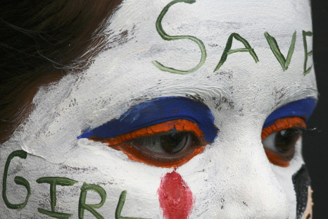 A girl with her face painted with an awareness message on female foeticide