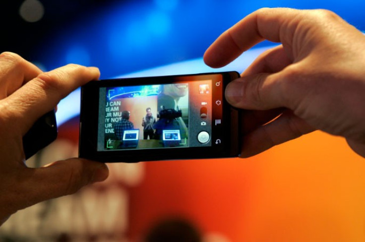 A man takes a photo with a Motorola Milestone smartphone, sister phone to the Motorola Droid, during the 2010 International Consumer Electronics Show (CES) in Las Vegas, Nevada January 8, 2010