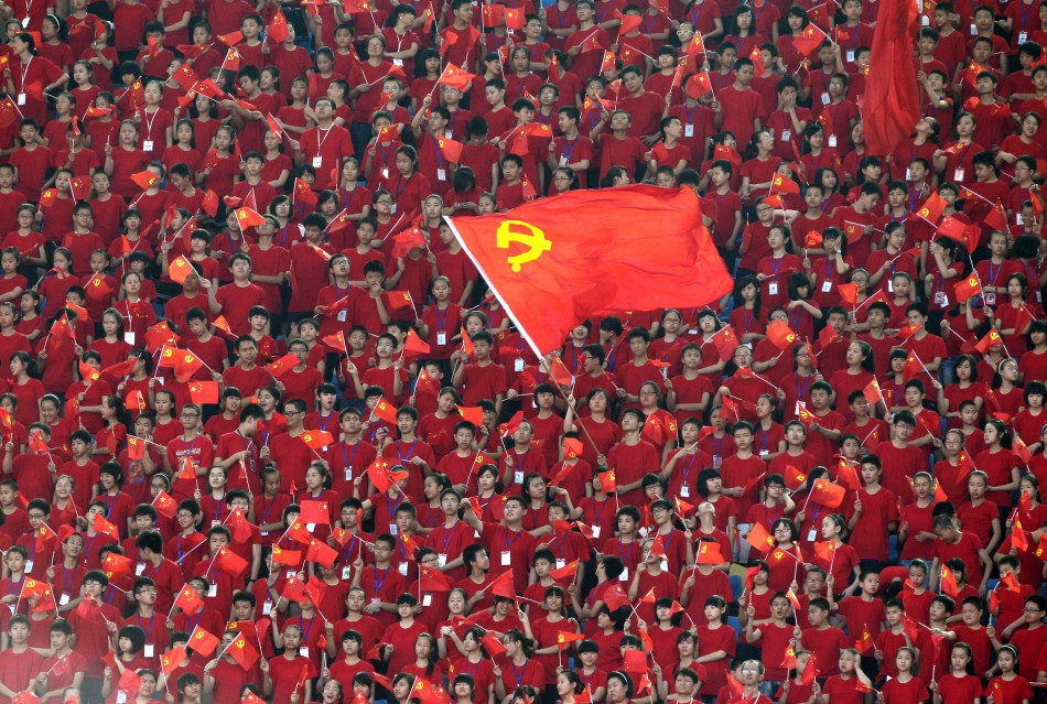 Students wave flags of CPC during opening ceremony of a revolutionary song singing concert in Chongqing municipality