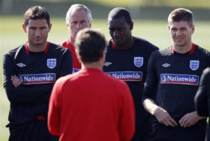 England's coach Fabio Capello (back to camera) speaks to Steven Gerrard (R), Emile Heskey (2nd R) and Frank Lampard (L) during a World Cup soccer training session at the Royal Bafokeng Sports Campus near Rustenburg June 21, 2010.