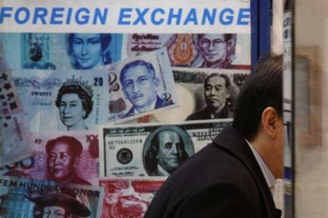 A customer is served at a counter inside a foreign exchange store displaying a poster of various banknotes including the Chinese yuan or renminbi (RMB) in Hong Kong November 20, 2009.