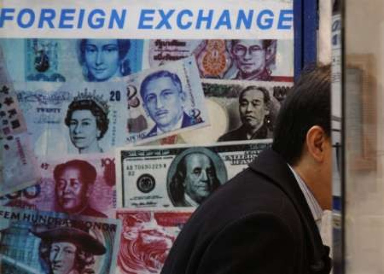 A customer is served at a counter inside a foreign exchange store displaying a poster of various banknotes including the Chinese yuan or renminbi (RMB) in Hong Kong November 20, 2009.
