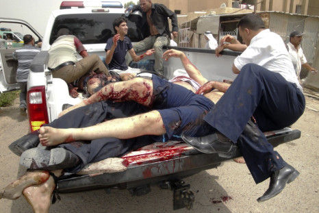 Bodies are loaded onto a police vehicle near the site of bombings in the town of Taji