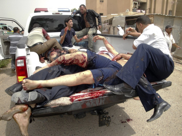 Bodies are loaded onto a police vehicle near the site of bombings in the town of Taji