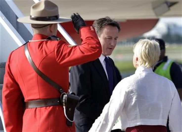 A Royal Canadian Mounted Police officer salutes as Britain&#039;s Prime Minister Cameron arrives at Pearson International Airport for the G8 and G20 summits in Toronto