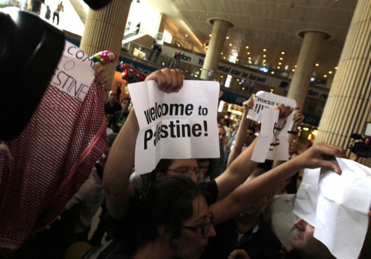 Pro-Palestinian Israeli activists hold signs during a protest at Ben Gurion International Airport near Tel Aviv
