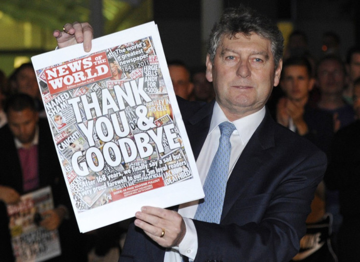 Colin Myler, editor of the News of The World, holds up a copy of the last edition of the newspaper outside the newspaper's office in Wapping
