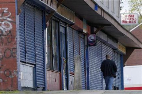 A man walks past a parade of closed shops in Liverpool.
