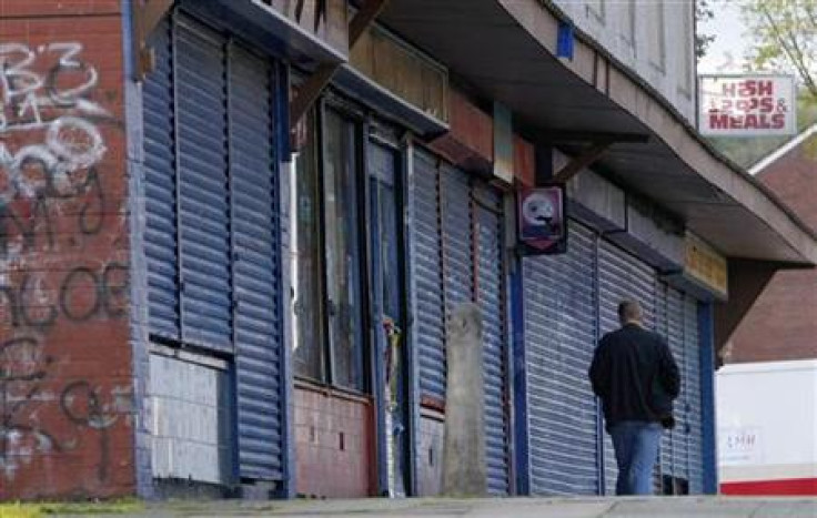 A man walks past a parade of closed shops in Liverpool.