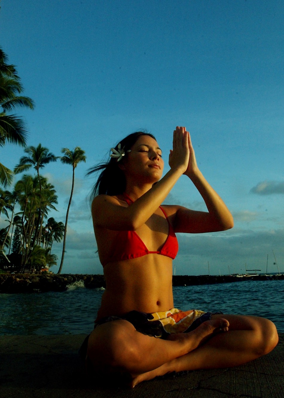 WOMAN MEDITATES ON HAWAI BEACH.