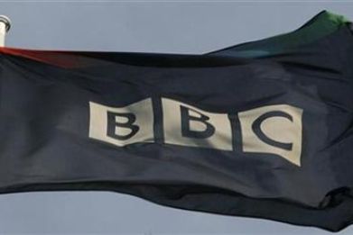 A tattered flag flies in a strong breeze above the BBC headquarters in London