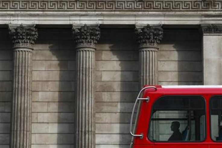 A man travels in a double-decker bus as it passes the Bank of England in central London
