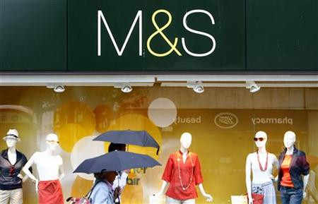 Shoppers walk past a Marks and Spencer store in central London