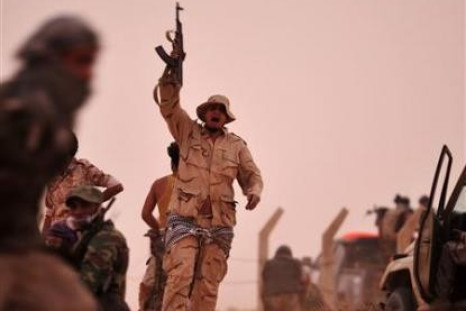 A rebel fighter holds a weapon during a shootout with forces loyal to Libya's leader Muammar Gaddafi on the outskirts of Al-Briqa, west of Ajdabiyah