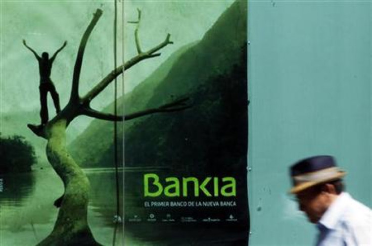 A man walks past a poster of savings bank Bankia in Madrid