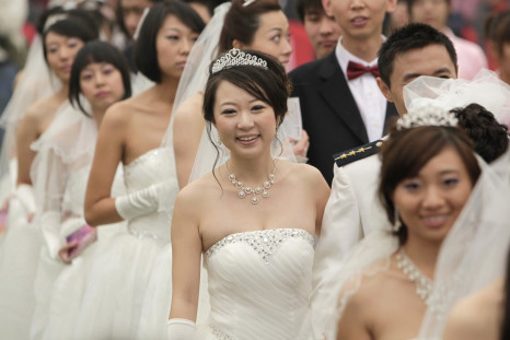 Couples take part in a mass wedding ceremony at the Olympic Park in Beijing October 10, 2010. Sixty couples took part in a mass wedding ceremony which started at 10:10 in the morning on the tenth day of the tenth month in the tenth year of the 21st centur