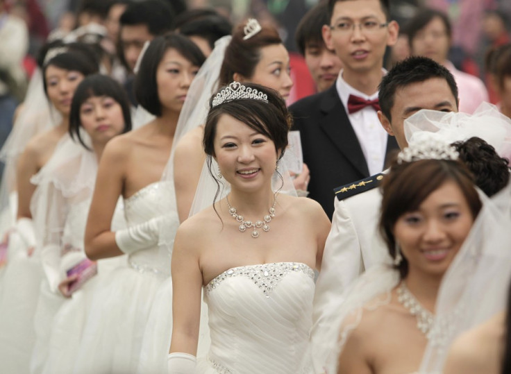 Couples take part in a mass wedding ceremony at the Olympic Park in Beijing October 10, 2010. Sixty couples took part in a mass wedding ceremony which started at 10:10 in the morning on the tenth day of the tenth month in the tenth year of the 21st centur