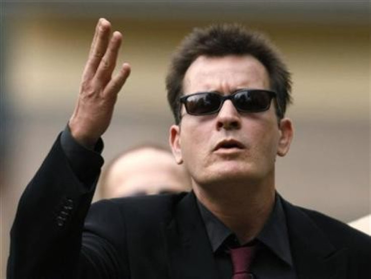 Charlie Sheen gestures towards fans as he arrives for a sentencing hearing at the Pitkin County Courthouse in Aspen, Colorado