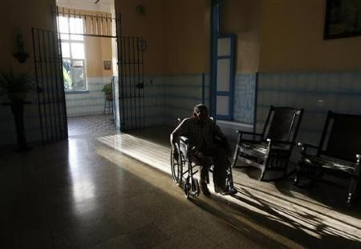 An elderly man rolls along in his wheelchair at the Santovenia Asylum in Havana July 6, 2009.
