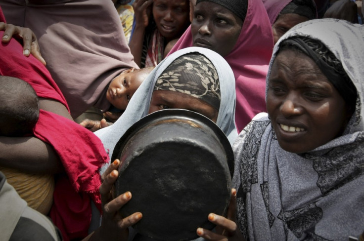 A woman covers her face with a cooking pot as she queues for food in a camp established by the Somali Transitional Federal Government for the internally displaced people in Mogadishu A woman covers her face with a cooking pot as she queues for food in a camp established by the Somali Transitional Federal Government for the internally displaced people in Mogadishu