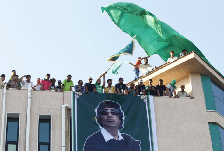 Supporters of Libya&#039;s leader Muammar Gaddafi look on during a rally in the town of Al-Ajaylat