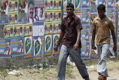 Two boys walk past local government election campaign posters in Jaffna