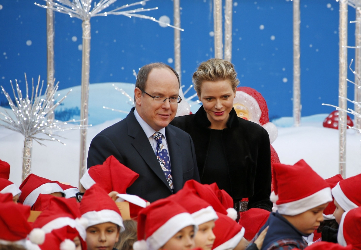 The royal couple of Monaco pose with children during Christmas tree ceremony.