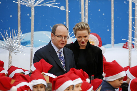 The royal couple of Monaco pose with children during Christmas tree ceremony.